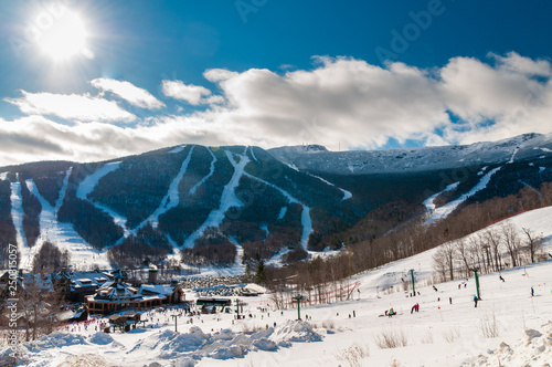 Spruce Peak Lodge in the winter with Mt. Mansfield in the background, Stowe, Vermont, USA