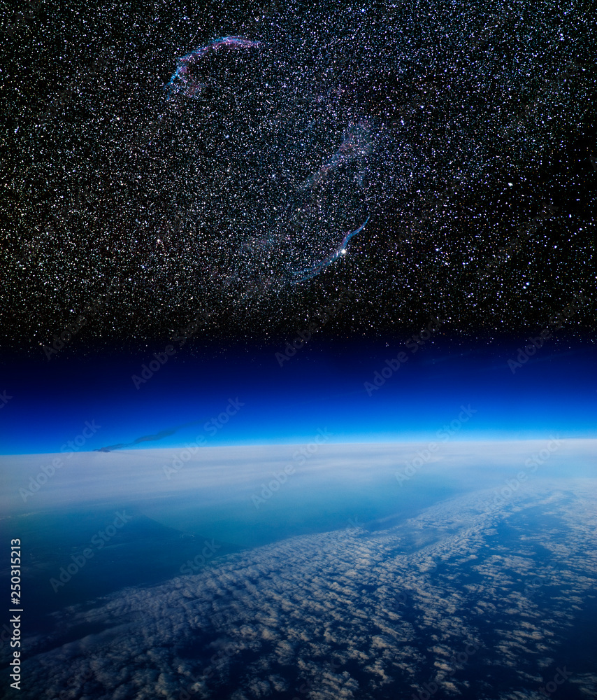 Obraz premium High altitude view of the Earth in space and the Veil nebula. This nebula, in the constellation of Cygnus, is the remains of a supernova explosion.