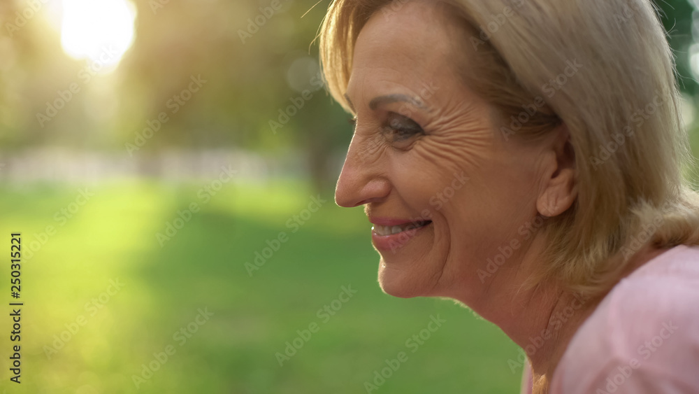 Beautiful wrinkled pensioner female smiling and looking at husband with love Beautiful wrinkled pensioner female smiling and looking at husband with love