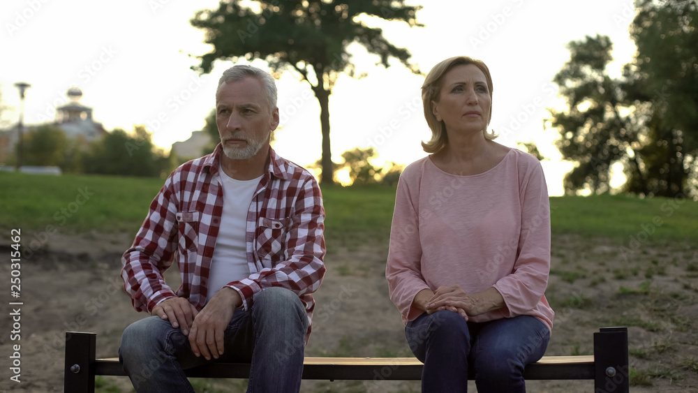 Fototapeta premium Offended elderly couple sitting on bench and thinking about divorce, relations