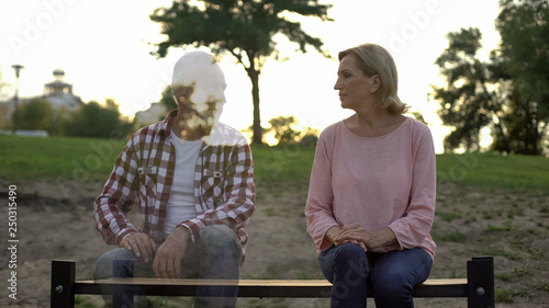 Fotografia Depressed old woman sitting on bench, husband appearing beside, loss, memories