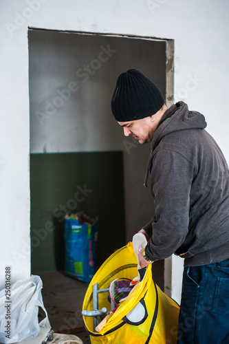 The worker takes out things from the repaired premises.