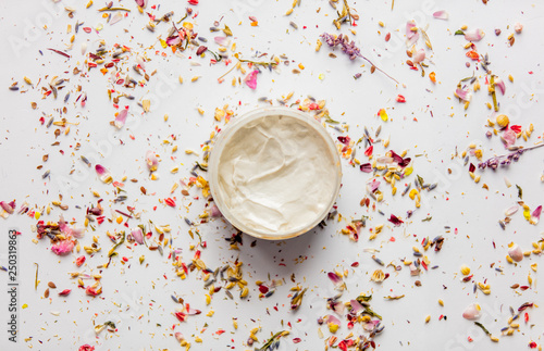 Skincare cream in a jar with lavender flower petals and leaves