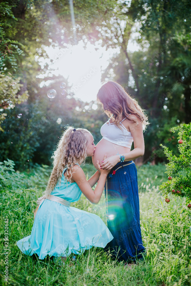 Fototapeta premium pregnant mother and daughter happy in the field