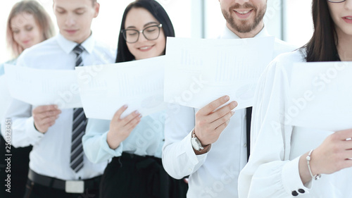 group of employees with documents standing in a row