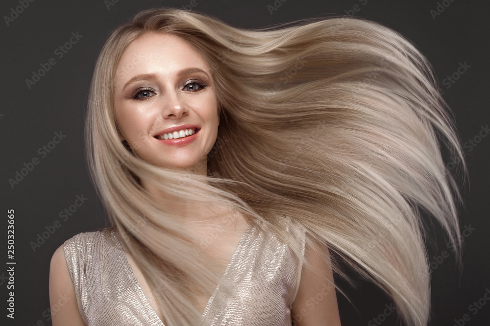 Naklejka premium Beautiful blond girl in move with a perfectly smooth hair, and classic make-up. Beauty face.