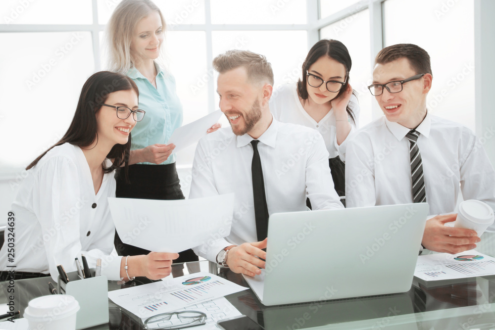 group of self-confident businessmen analyzing data using a laptop group of self-confident businessmen analyzing data using a laptop