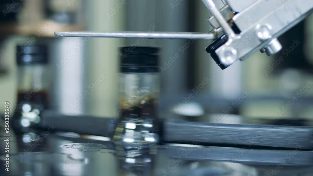 Alcohol factory equipment putting lids on bottles, modern technology. Alcohol factory equipment putting lids on bottles, modern technology.