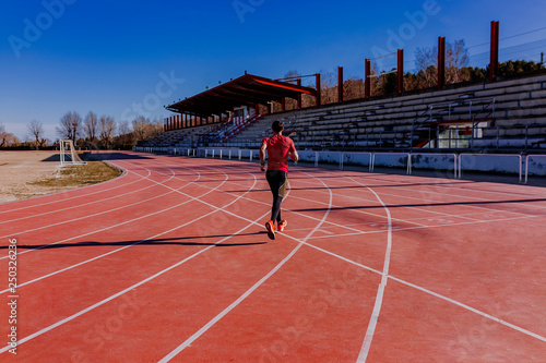 young athlete man running in the lanes. Daylight. Sports concept