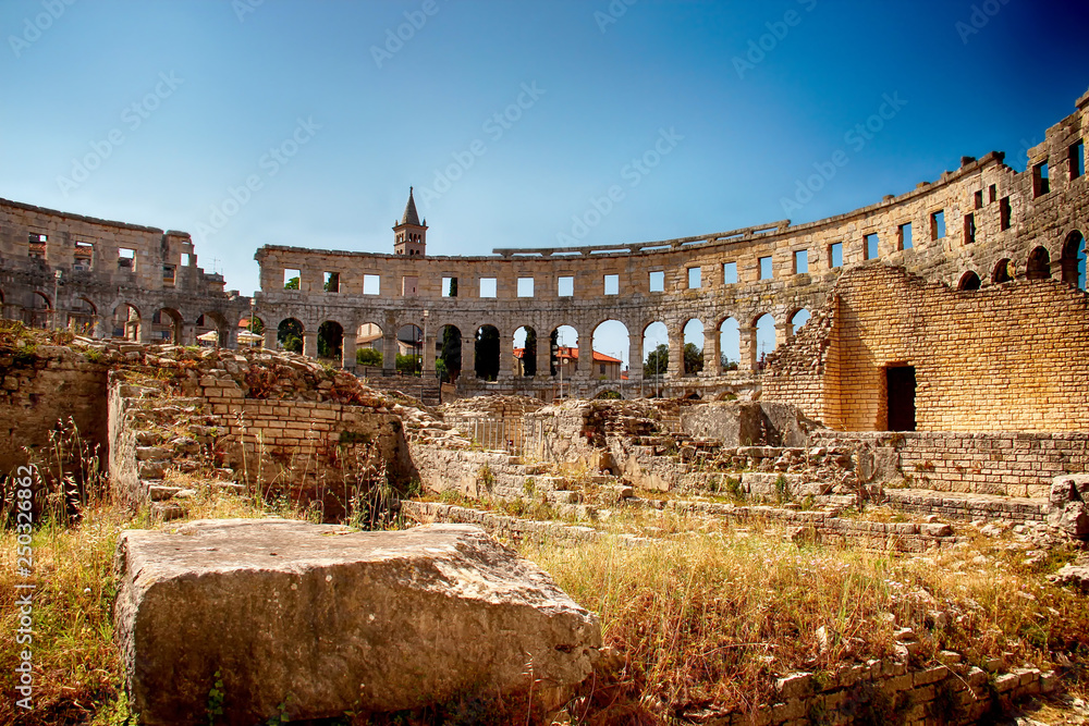 Amphitheater in Pula. There is blue sky and stones walls.