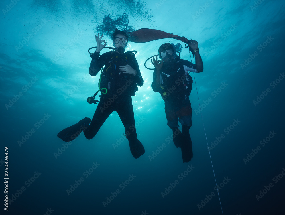 Young woman and man scuba divers exploring Young woman and man scuba divers exploring