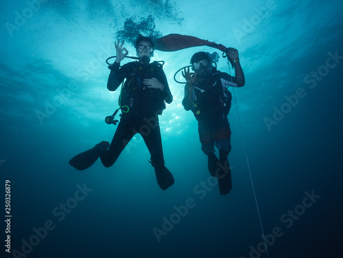 Young woman and man scuba divers exploring