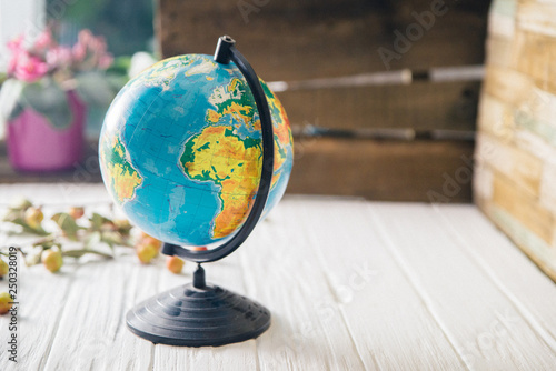 Globe on wooden white boards with a blurred background. Autumn still life