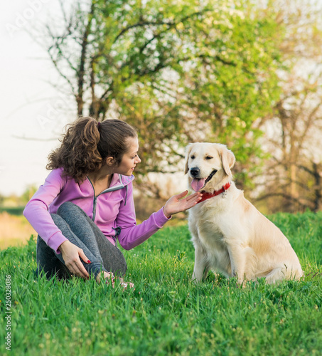 Portrait of young beautiful woman sitting and hugging her golden retriever dog. Happiness and friendship. pet and woman.