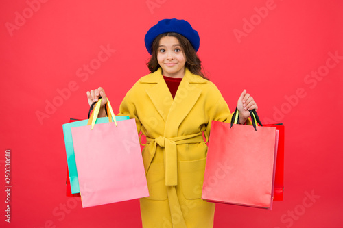 Obsessed with shopping. Girl cute kid hold shopping bags red background. Get discount shopping on birthday holiday. Fashionista adore shopping. Customer satisfaction. Prime time buy spring clothing