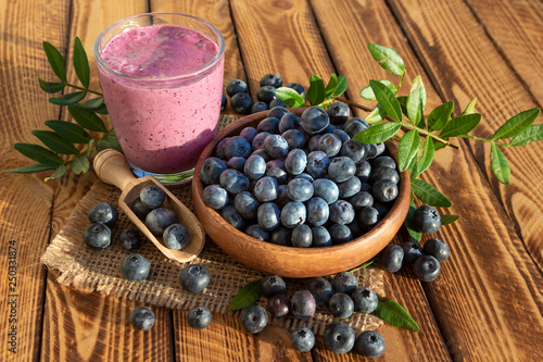 Blueberries smoothie with fresh berries on wooden background