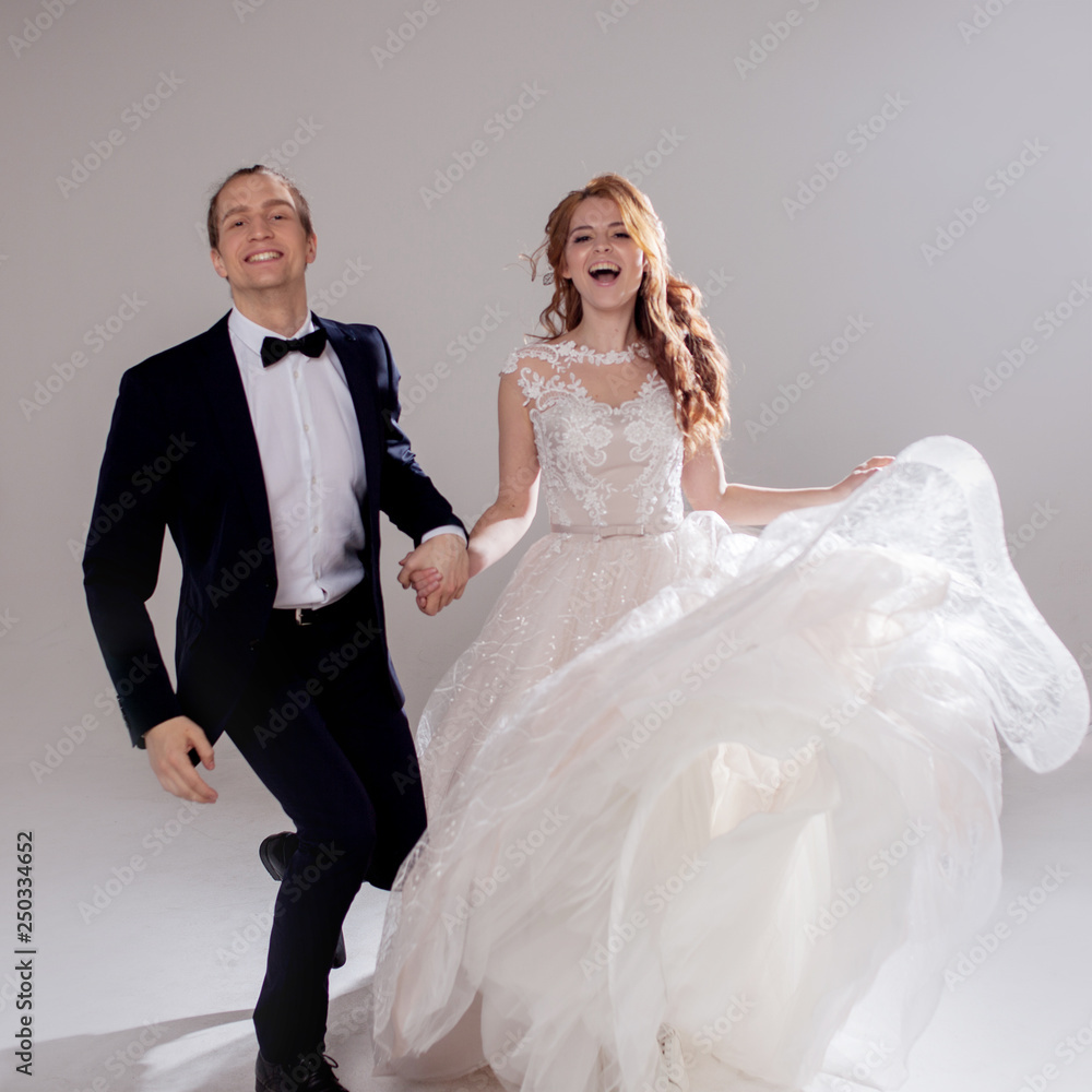 Happy young couple laughing and dancing together. The couple in the Studio a light background.