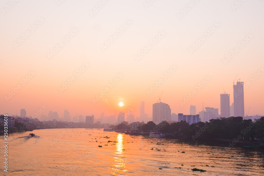 In the morning sunrise in to sky. Early morning sunrise over the river and building. Photo landscape Bangkok Thailand.