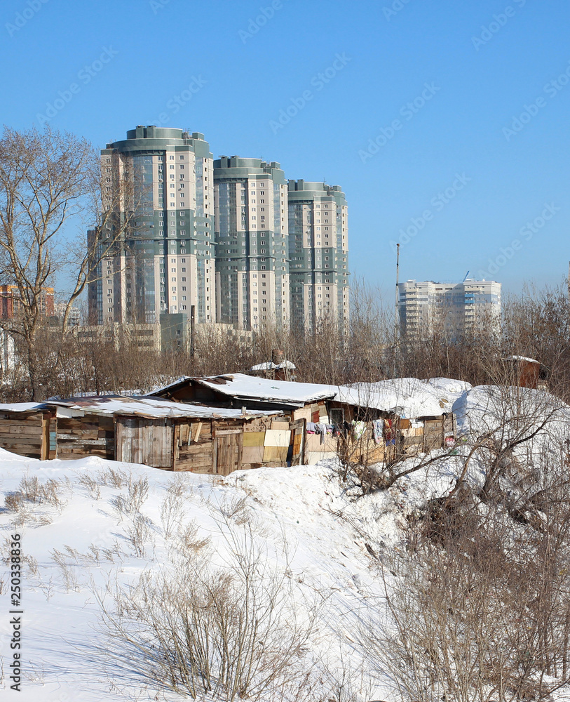 high modern buildings multi-storey buildings rise above the old historical low-rise buildings of wooden houses in winter Novosibirsk historical high modern buildings multi-storey buildings rise above the old historical low-rise buildings of wooden houses in winter Novosibirsk historical