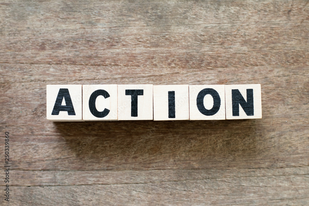 Letter block in word action on wood background Letter block in word action on wood background