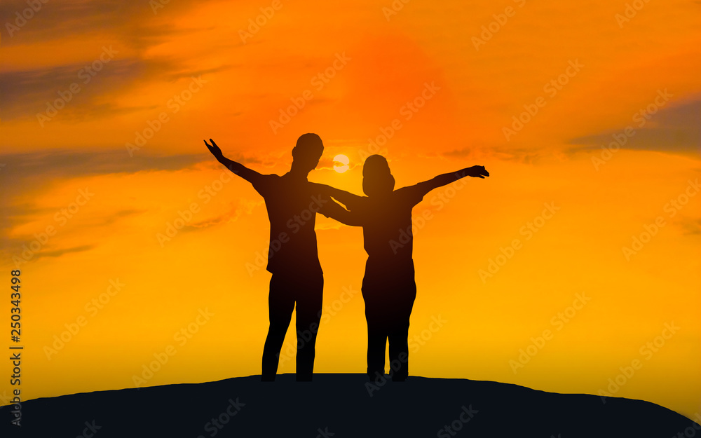 Man and woman in love. They are standing and see the sun set. Woman wearing a hat and man Man hugging woman.Photo concept Silhouette and love. 