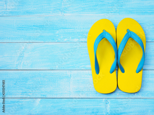 yellow flip flop shoes on blue wooden background