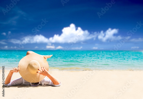 woman relax on the beach. Happy island lifestyle. White sand, blue cloudy sky and crystal sea of tropical beach. Vacation at Paradise. Ocean beach relax