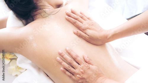 beautiful and healthy woman enjoying during a back massage in spa salon