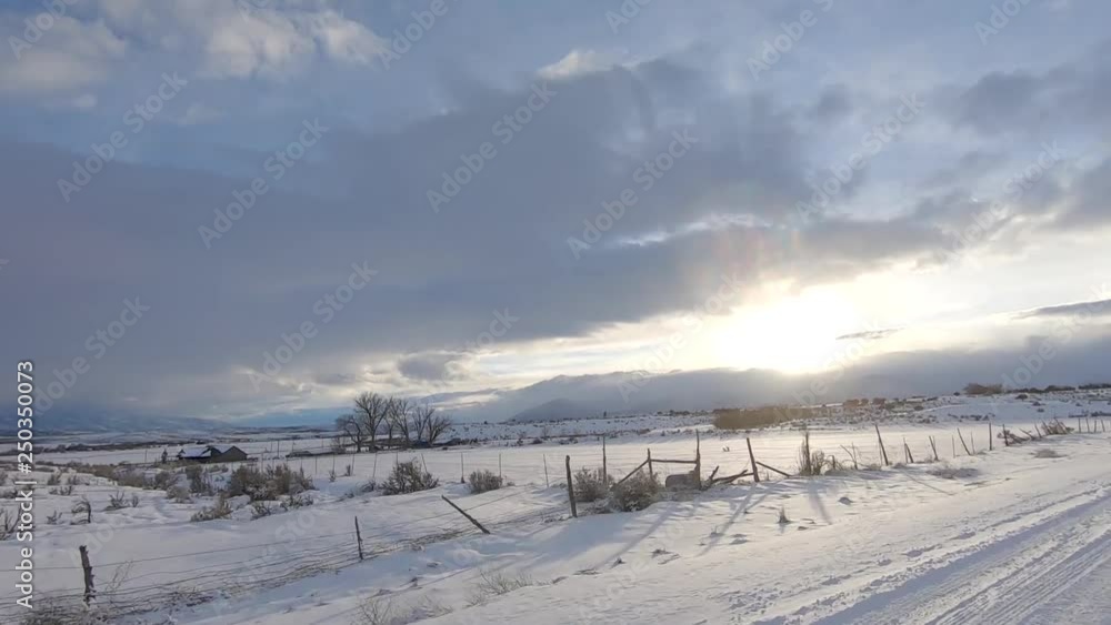 Drive Plate-POV-Side view passing snowy fields to setting sun passing farms and fields Drive Plate-POV-Side view passing snowy fields to setting sun passing farms and fields