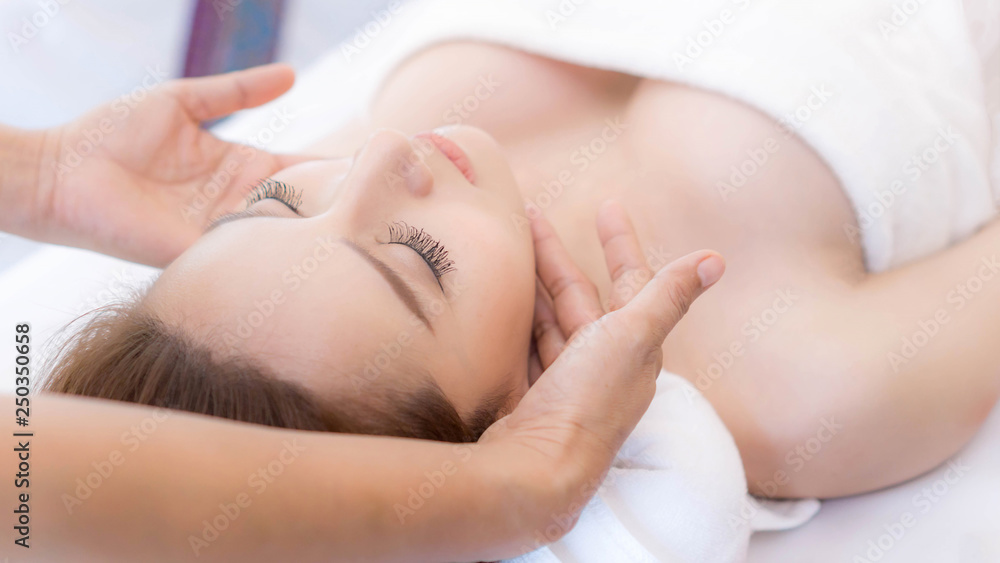beautiful and healthy young woman relaxing with face massage at beauty spa salon beautiful and healthy young woman relaxing with face massage at beauty spa salon