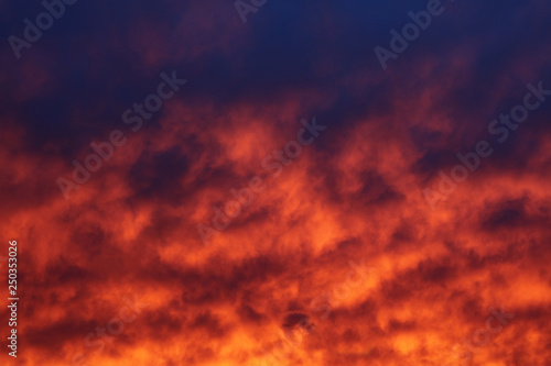 The sky and brightly illuminated clouds at sunset as the background for the design.