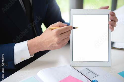 Close up business man hand holding tablet with pen pointing white screen in office.