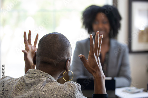 Obraz na plátne Black female client is upset at tax preparer or CPA accountant in an office