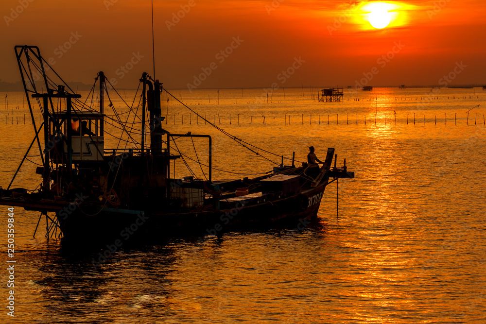 Sun reflects the sea with fishing boats