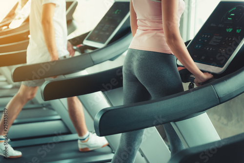 Portrait of Couple Love is Workout in Fitness Gym Together. Attractive Woman is Working Out Jogging on Treadmill Machine With Her Exercise Trainer., Sport Club and Healthy Concept.
