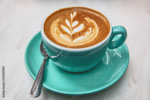 Photography Latte art in cappuccino coffee cup at cafe table