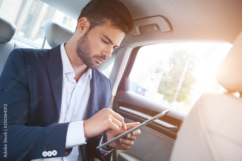 Portrait of businessman using digital tablet while travelling