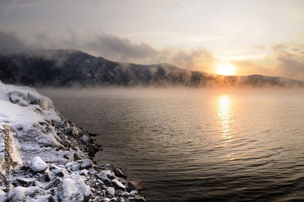 Yenisey river bank covered with snow during foggy winter sunrise near Krasnoyarsk in Siberia, Russia Yenisey river bank covered with snow during foggy winter sunrise near Krasnoyarsk in Siberia, Russia