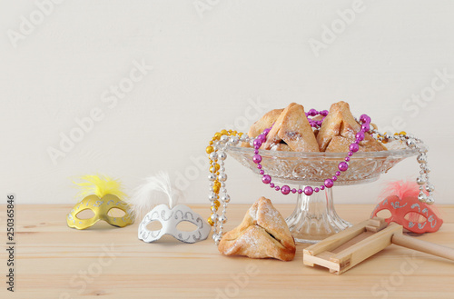 Purim celebration concept (jewish carnival holiday) over wooden table. photo