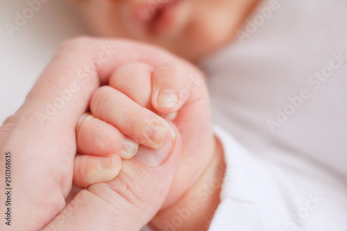baby's hand in mother's hands