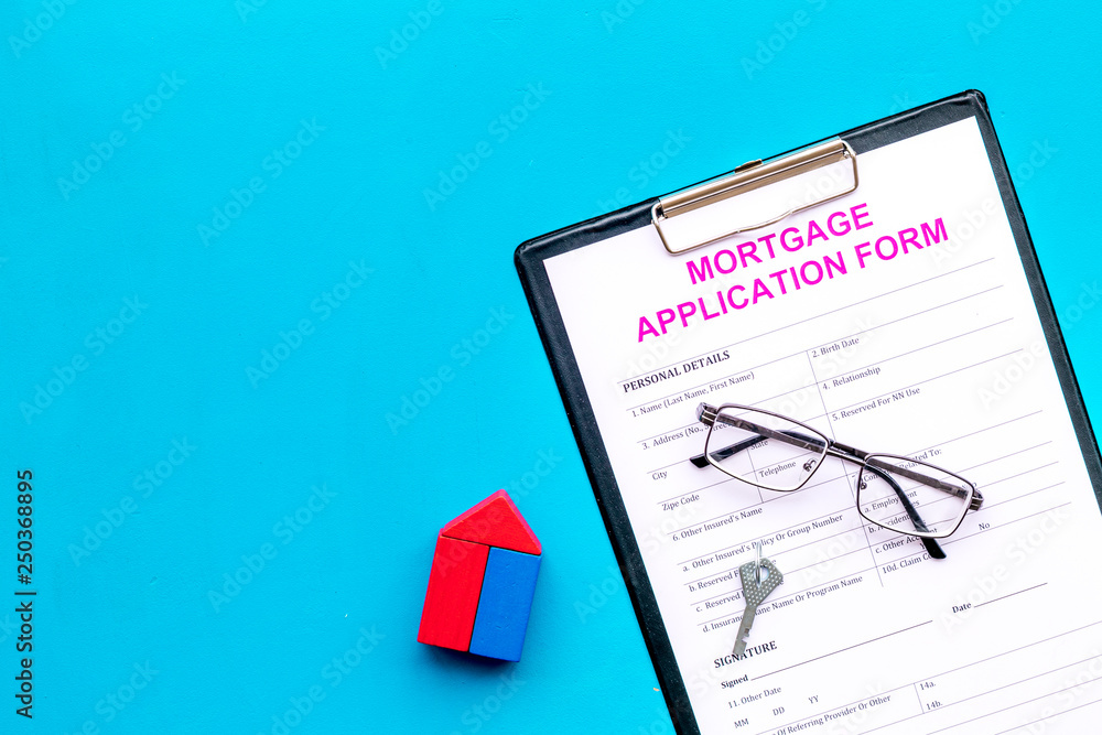 Mortgage concept. Mortgage application form near key and house made of constructor on blue background top view space for text Mortgage concept. Mortgage application form near key and house made of constructor on blue background top view space for text