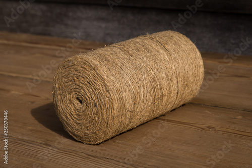 A roll of twine on a wooden background. Selelective focus. Close-up. Free space for text.