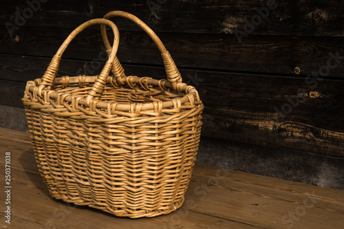 Ancient wicker basket on a wooden background. Selective focus. Free space for text.