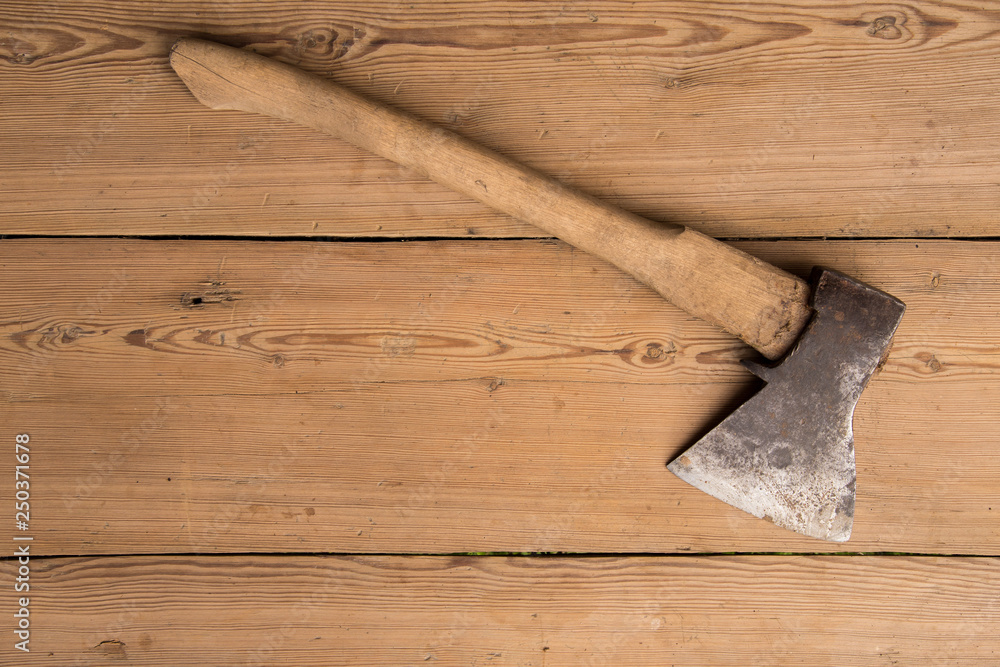 Old ax with a wooden handle stuck in wooden log. Concept for woodworking or deforestation. Selective focus.