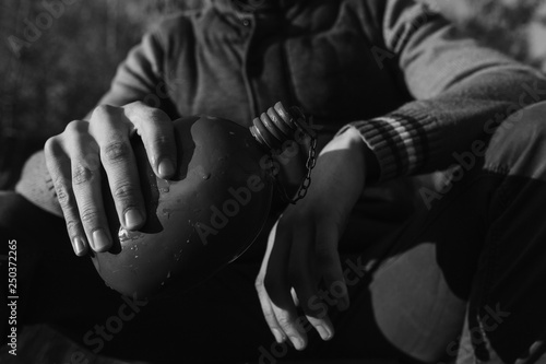 The flask in the man hands. Black and white