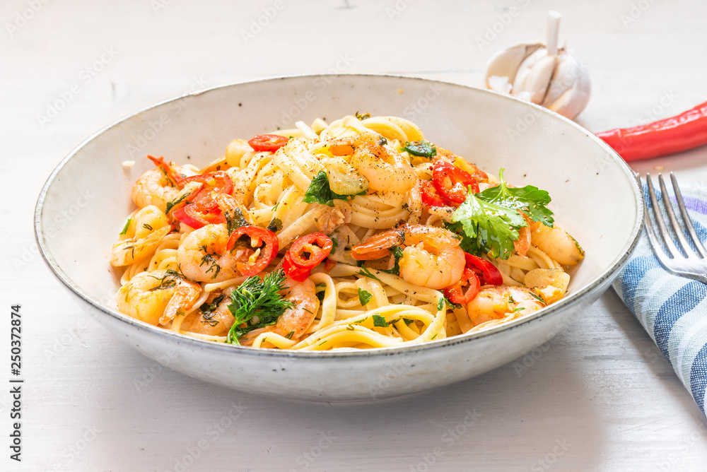 Linguine with shrimps on a rustic plate close-up - traditional Mediterranean pasta with seafood, Italian cuisine. Linguine with shrimps on a rustic plate close-up - traditional Mediterranean pasta with seafood, Italian cuisine.