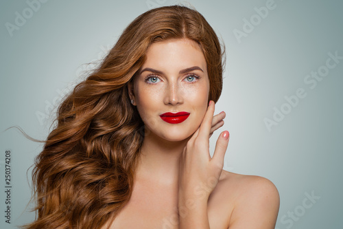 Perfect red haired woman. Elegant redhead girl with curly hairstyle. Smiling woman portrait