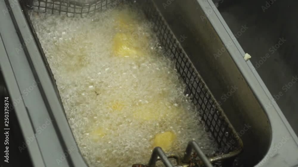 Close up potatoes are fried in a restaurant Deep fryer in slow motion