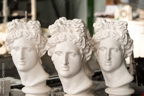 Gypsum sculptures. The heads of the gypsum apollo in the workshop.
