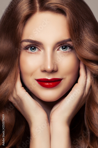 Perfect female face closeup portrait. Pretty woman with curly shiny hair and red lips makeup